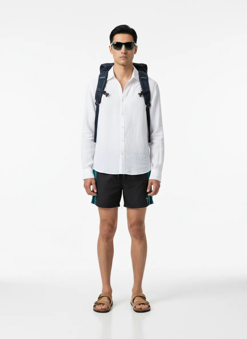 Beach-day Outfit Idea: Man's black swim trunks with teal accents